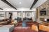 Elegant living room with modern decor, featuring cozy seating, a rustic stone fireplace, and warm ambiance lighting.