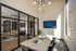 Chic modern apartment with glass-wall office, elegant dining table, natural lighting, and contemporary decor.