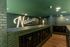 Chic mailroom with green brick walls and sleek black mailboxes at Nations, Nashville, TN, offering modern convenience in a stylish setting.