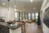 Modern apartment interior with open kitchen and cozy living room featuring stylish decor and large windows, offering natural light and a warm ambiance.
