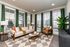 Elegant and modern living room with floor-to-ceiling windows, stylish green curtains, plush beige sofa, and contemporary decor.