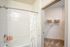 Inviting bathroom with elegant tub and organized closet space, showcasing modern convenience and style.