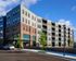 Modern apartment complex with a stylish facade, large windows, and multiple balconies nestled in a vibrant neighborhood.