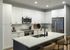 Modern kitchen with sleek white cabinetry, stainless steel appliances, and a stylish island with seating.