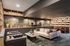 Elegant library lounge with stylish sofas, artistic wall decor, and cozy reading chairs set against a modern bookshelf backdrop.
