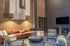 Chic living room with exposed brick walls, modern fireplace, cozy seating, and contemporary d&eacute;cor in warm tones.