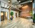 Contemporary open-plan dining area with elegant wood flooring, stylish brick accent wall, and modern lighting fixtures, ideal for gatherings.