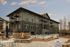 Elegant apartment complex with modern architecture, featuring balconies, a serene pool area, and a cozy outdoor firepit under a beautiful sky.
