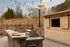 Charming outdoor kitchen with a stone countertop and grill, set against a scenic landscape with warm lighting and lush surroundings.