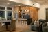Chic open-concept kitchen and living area with modern wood finishes, elegant lighting, and comfortable seating.