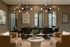 Elegant dining room with modern lighting, luxurious tan leather chairs, and artistic wall decor, ideal for sophisticated gatherings.