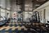 Modern, well-lit fitness center featuring state-of-the-art exercise equipment, stylish design, and ample natural light through large windows.