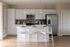 Bright, modern kitchen featuring sleek white cabinetry, stainless steel appliances, and a chic island with elegant pendant lighting.