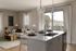 Bright and modern living space featuring an open-concept kitchen with island, cozy living room with elegant decor, and large windows offering natural light and scenic views.