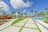 Luxurious apartment complex featuring a sparkling swimming pool, cozy hammocks under elegant cabanas, and lush tropical landscaping.