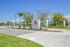 Inviting entrance of Aspire community showcasing modern signage, vibrant landscaping, and clear blue skies.