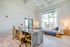 Bright contemporary lounge area with a marble workspace, cozy seating, and large windows showcasing lush greenery.