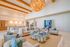 Elegant living room with vaulted ceilings, featuring a luxurious chandelier, cozy seating area, and modern open kitchen design.