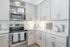 Modern kitchen with sleek stainless steel appliances, stylish white cabinetry, and elegant countertops exuding sophistication and functionality.