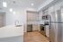 Modern kitchen with sleek stainless steel appliances, elegant cabinetry, and a spacious quartz countertop island with pendant lighting.