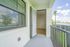 Inviting apartment balcony with a tranquil water view, featuring lush greenery and modern architecture.