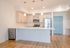 Modern kitchen with sleek stainless steel appliances, elegant pendant lighting, and spacious countertops, showcasing contemporary design and functionality.
