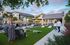 Luxurious apartment exterior featuring a vibrant garden, poolside lounge chairs, and a welcoming community area beneath a clear sky.