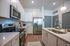 Modern kitchen with sleek stainless steel appliances, stylish white cabinetry, and elegant pendant lighting.