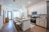 Modern apartment kitchen with sleek white cabinetry, stainless steel appliances, and a stylish breakfast bar with cozy seating.