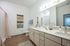 Elegant bathroom with modern light fixtures, spacious vanity, and a chic wall tapestry adding warmth and style.