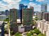 Modern high-rise apartment complex with panoramic city views, offering luxurious living and a rooftop pool.
