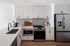 Elegant modern kitchen with sleek white cabinets, stainless steel appliances, and a stylish backsplash.
