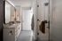 Elegant bathroom with modern fixtures, spacious vanity, and sleek glass shower, offering a luxurious feel.