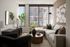 Bright and modern living room with large windows, stylish decor, and a cozy sectional sofa.