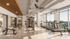 Modern, sunlit gym with sleek equipment, large windows offering scenic views, and elegant decor.