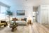 Inviting living room with elegant decor, featuring a chic couch, modern art, and abundant natural light creating a cozy yet stylish atmosphere.