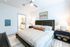 Inviting bedroom with elegant decor, king-size bed, and en-suite bathroom, featuring modern furnishings and calming color palette.