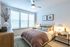 Bright and cozy bedroom with large windows, elegant decor, and a comfortable bed for a serene retreat.