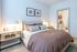 Inviting bedroom with elegant decor, a cozy bed with plush pillows, and soft lighting, leading to a stylish en-suite bathroom.