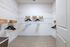Spacious walk-in closet featuring sleek wire shelving, elegant wooden hangers, and stylish wicker baskets, ideal for organized living.