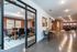 Modern office space with sleek conference room, cozy seating area, and stylish exposed brick walls.