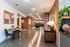 Contemporary open-concept living space with polished concrete floors, exposed brick walls, and stylish furnishings, perfect for modern urban living.