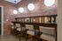 Chic urban bar area with modern bar stools, ambient lighting, and an elegant brick wall backdrop.