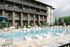 Luxurious apartment complex showcasing a pristine swimming pool with stylish loungers and lush landscaping.