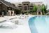 Luxurious apartment complex showcasing an inviting pool area with modern loungers, surrounded by lush greenery and stylish architecture.