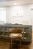 Chic apartment reception area with a modern aesthetic, featuring a sleek gray desk, elegant lighting, and a stylish leather chair.