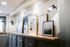 Elegant apartment lobby showcasing stylish framed artwork above sleek mailboxes, illuminated by modern wall sconces.