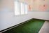 Charming pet-friendly nook with playful dog-themed wall art and lush artificial turf, perfect for your furry companions.