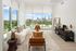 Sleek urban living room with panoramic city skyline views, featuring modern furnishings and abundant natural light.