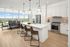 Modern kitchen with sleek white cabinetry, large island, and stunning city view from floor-to-ceiling windows.